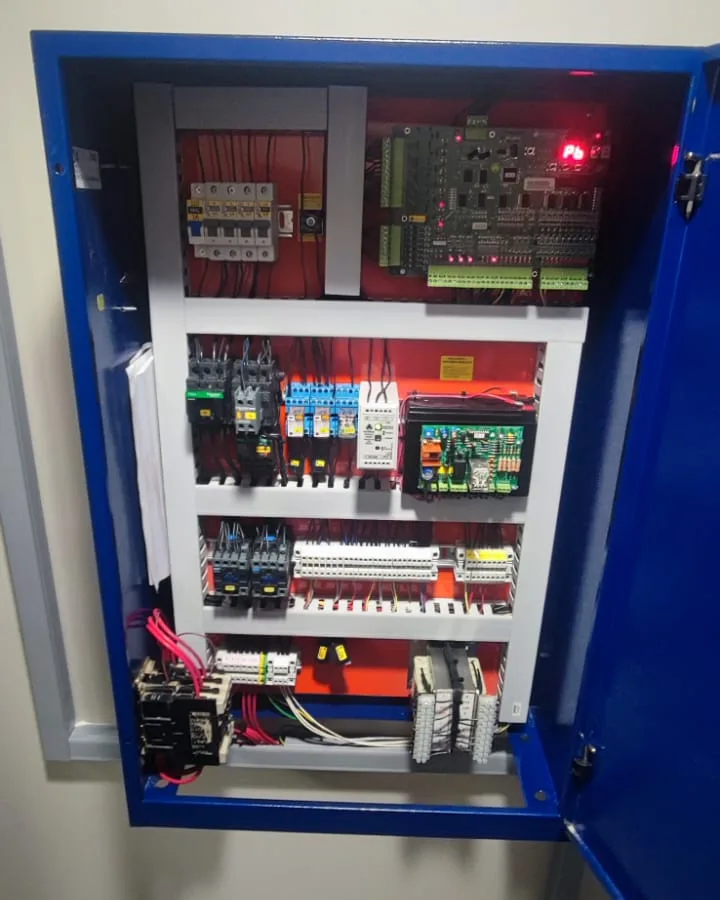 Tablero de maniobra de ascensor abierto, con placa electrónica y contactores